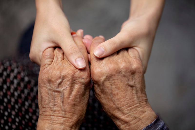 Holding elderly persons hand